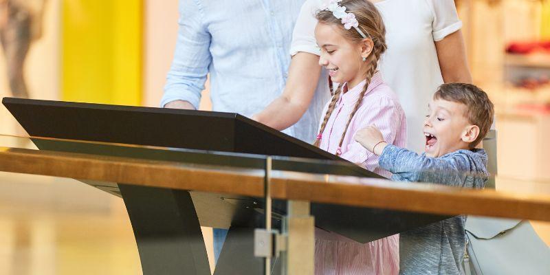 children all excited and happy while interacting with a digital kiosk in museum